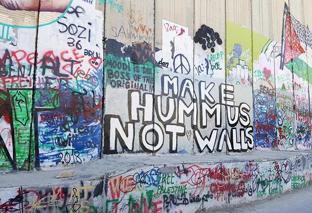 Grafitti saying 'Make hummus not war' painted on a wall