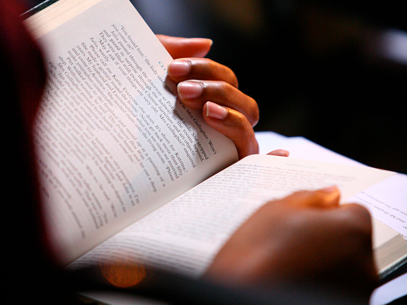 Hands holding an open Bible