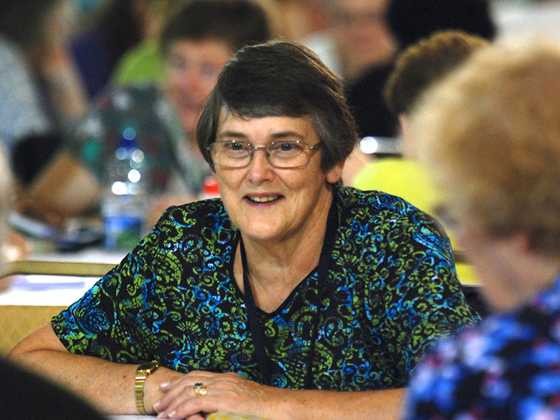 Woman sat at a table with arms crossed