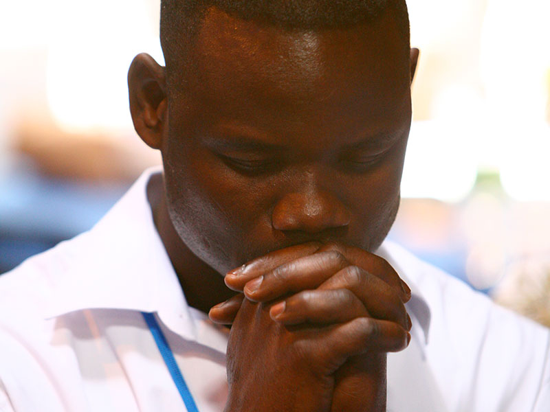 Man with his hands to his face in contemplation/prayer