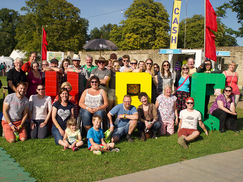 People sat by large URC lettering at Greenbelt