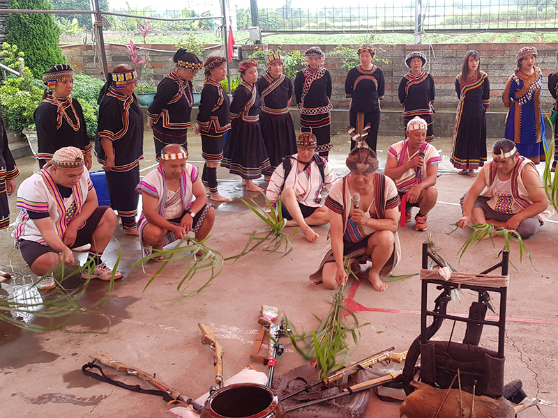 A group of people in traditional Taiwanese dress praying.